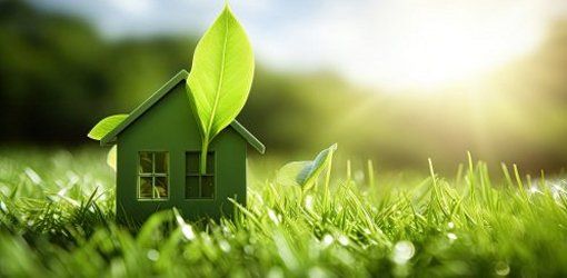 INNOVAZIONI NELLA BIOEDILIZIA: COME COSTRUIRE CASE SOSTENIBILI 1 Modellino di casa verde con foglie che crescono sul tetto, immerso in un prato rigoglioso con luce solare sullo sfondo